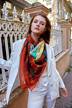 Load image into Gallery viewer, Discover the harmony of tradition and contemporary elegance with this timeless wool shawl. This large hand-stitched shawl radiates warmth through its tones of red, orange, green, blue sunset colours, evoking a vibrant energy and life-giving power.
