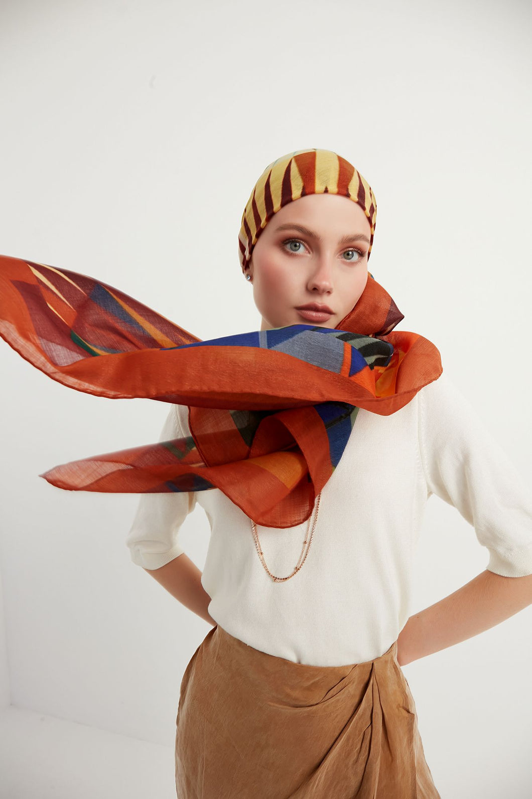 Discover the harmony of tradition and contemporary elegance with this timeless wool shawl. This large hand-stitched shawl radiates warmth through its tones of red, orange, green, blue sunset colours, evoking a vibrant energy and life-giving power.