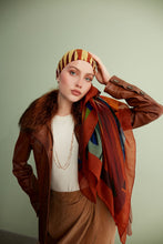 Charger l&#39;image dans la galerie, Discover the harmony of tradition and contemporary elegance with this timeless wool shawl. This large hand-stitched shawl radiates warmth through its tones of red, orange, green, blue sunset colours, evoking a vibrant energy and life-giving power.
