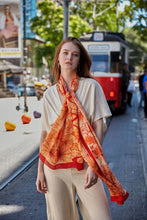 Load image into Gallery viewer, Discover the harmony of tradition and contemporary elegance with this timeless crepe silk shawl. This large shawl radiates warmth through its red, orange and beige sunset colours, evoking a vibrant energy and life-giving power.
