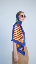 Load and play video in Gallery viewer, Discover the harmony of tradition and contemporary elegance with this timeless crepe silk shawl. This large shawl radiates warmth through its red, yellow and blue sunset colours, evoking a vibrant energy and life-giving power.
